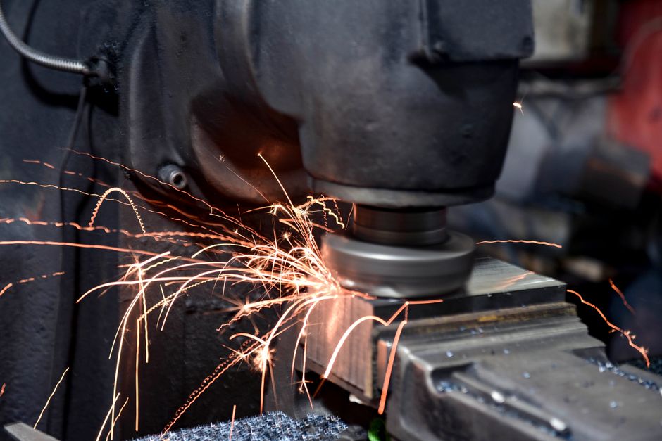 gemini spark india — Close-up of a grinding machine in action with sparks flying in an industrial setting.
