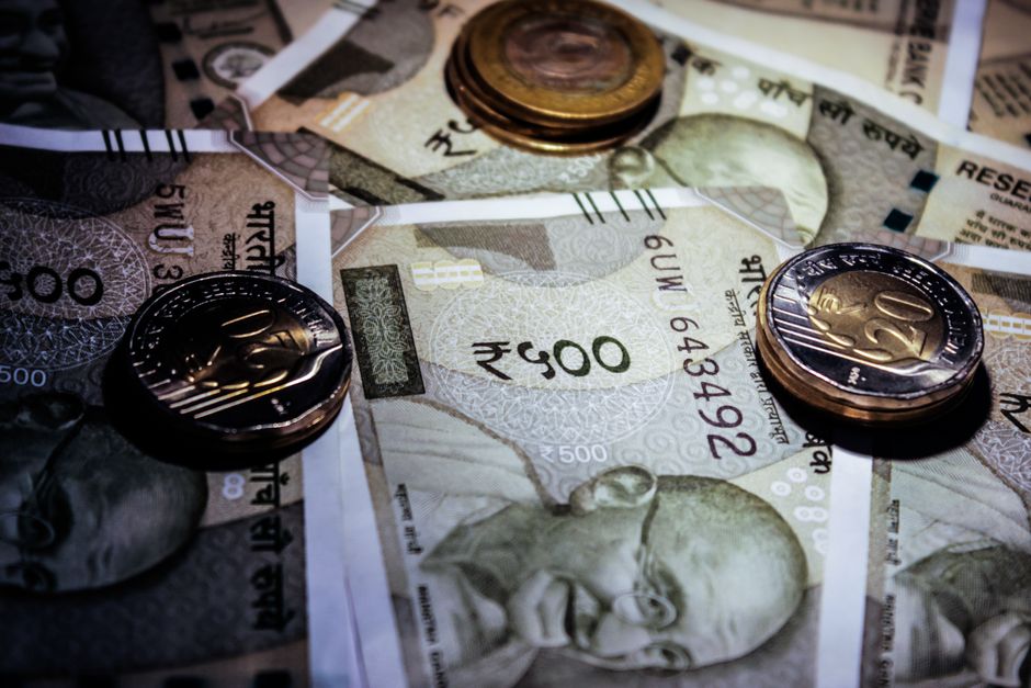 india growth forecast — Detailed close-up of Indian currency notes and coins, featuring Mahatma Gandhi portrait.