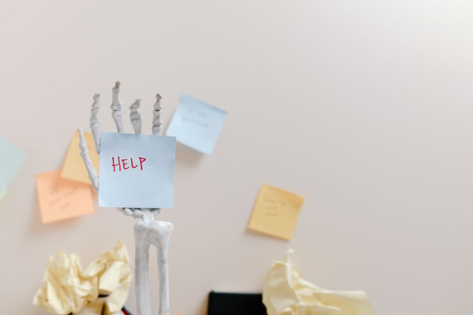 neet pg 2026 — Skeleton hand holding a sticky note with 'HELP' written, against colorful notes background.