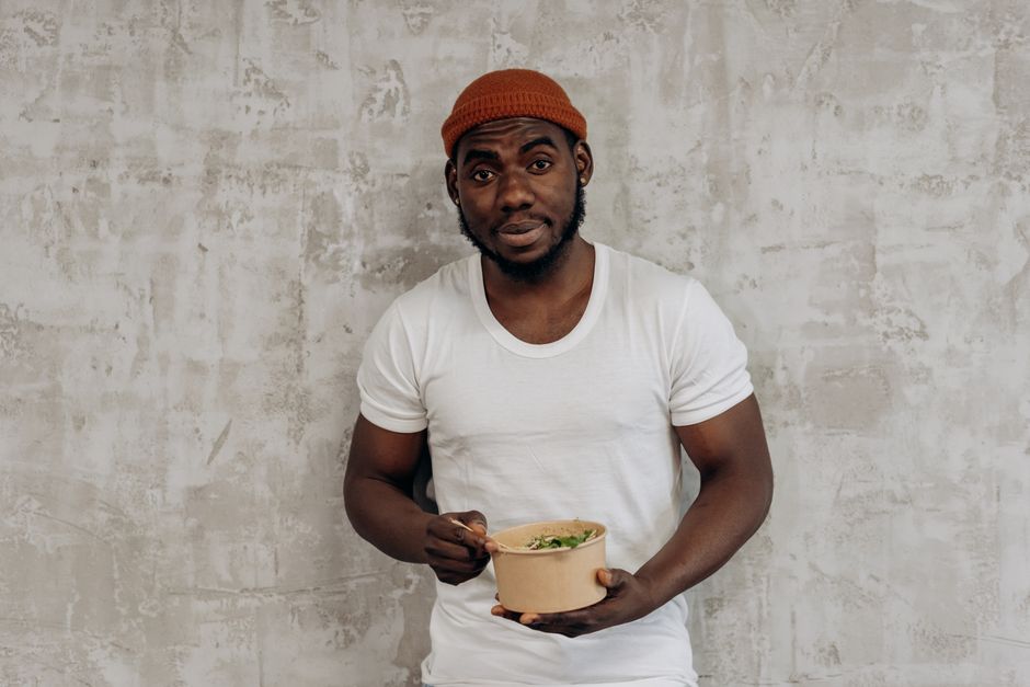 sanju samson fitness — Smiling man in a white t-shirt enjoying a healthy meal indoors, embodying a fit lifestyle.